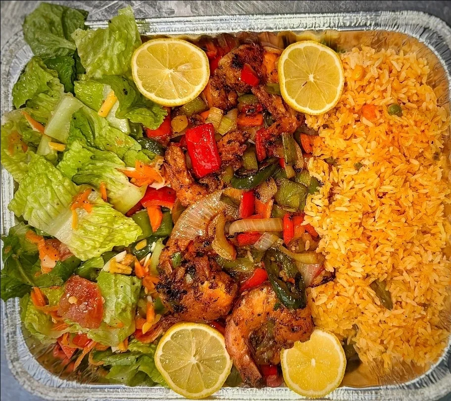 Grilled shrimp with peppers and onions over yellow rice and salad